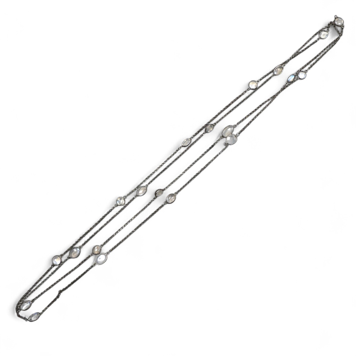A silver and moonstone longchain necklace, set with cabochon moonstones, connected by a fine link chain, length 128cm, Condition: overall good condition, attractive moonstones and nice design. Silver with typical tarnish